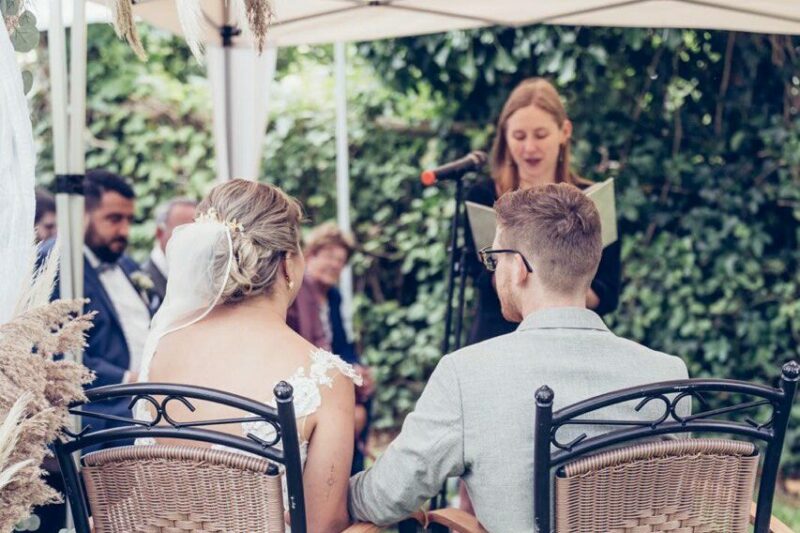 Braut und Bräutigam sitzen vor der Traurednerin